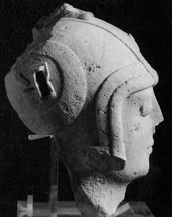 Description de l'image par IA : Buste en pierre, vue de profil, casque avec visière, support en plastique transparent.