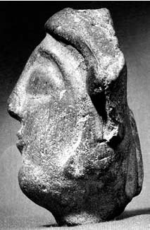 Description de l'image par IA : Tête de Saltés, profil gauche en pierre, vue de trois quarts.