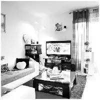 Description de l'image par IA : Salon avec canapé, télévision, étagères et rideaux.