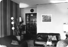 Description de l'image par IA : Salon avec canapé, lampe, porte vitrée, tableau.