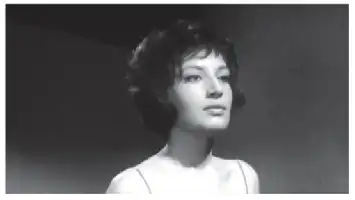 Description de l'image par IA : Femme aux cheveux courts, regard sérieux, vêtue de blanc, sur fond sombre.