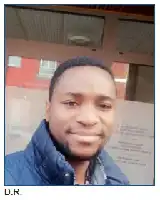 Description de l'image par IA : Portrait d'un homme souriant en veste bleue, tenant un livre avec du texte en braille.