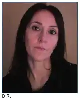 Description de l'image par IA : Femme aux longs cheveux noirs, regard sérieux, portant un col roulé sombre.