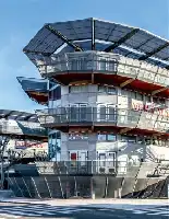 Description de l'image par IA : Bâtiment moderne avec plusieurs niveaux et balcons, toits en forme de dôme.