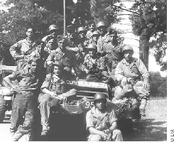 Description de l'image par IA : Un groupe de soldats espagnols posant devant un char nommé Guadalajara, avec des noms de batailles sur les véhicules.