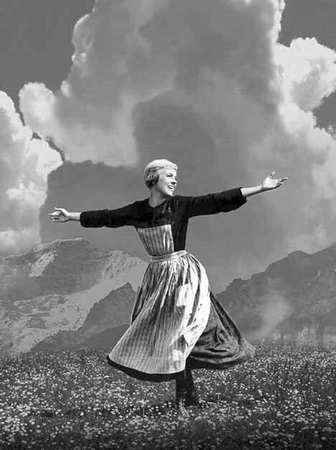 Description de l'image par IA : Femme avec une robe tournante dans un champ fleuri, bras ouverts, montagnes en arrière-plan.