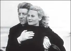 Description de l'image par IA : Un homme et une femme enlacés, regardant la caméra, sur fond de mer.
