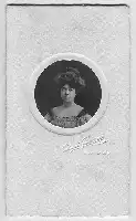 Description de l'image par IA : Portrait en noir et blanc d'une femme avec une coiffure élaborée, encadré dans un cercle blanc. Signature et date en bas.