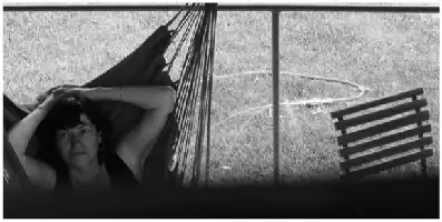 Description de l'image par IA : Femme se reposant dans un hamac, cadre extérieur, été 2004.