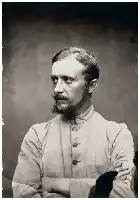 Description de l'image par IA : Homme barbu en costume colonial, bras croisés, regard sérieux.