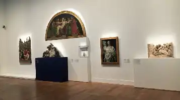 Description de l'image par IA : Salle d'exposition avec plusieurs œuvres d'art, y compris des reliefs et des peintures.
