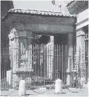 Description de l'image par IA : Portail en fer forgé avec des piliers en béton, menant à une arche ornée.