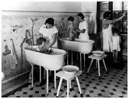 Description de l'image par IA : Femmes et enfants dans une salle de bain, lavant des bébés dans des baignoires.