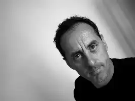 Description de l'image par IA : Portrait en noir et blanc d'un homme avec des cheveux courts, regardant directement la caméra avec un fond blanc.