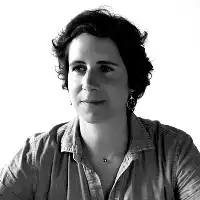 Description de l'image par IA : Femme aux cheveux courts, regard sérieux, chemise décontractée.