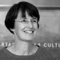 Description de l'image par IA : Femme aux cheveux courts et lunettes, souriante, en noir et blanc.